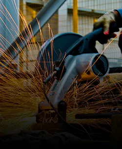 Steel & metal manufacturing: close-up of a CNC machine cutting a steel pipe with sparks